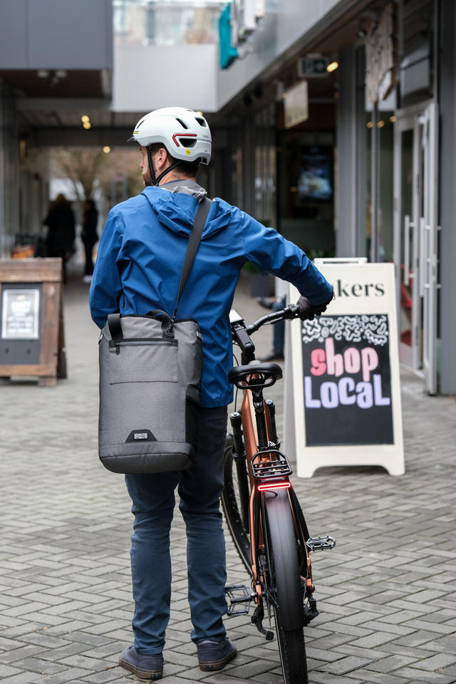 Two Wheel Gear Grey Solo Market Pannier  being carried with shoulder strap at outdoor market