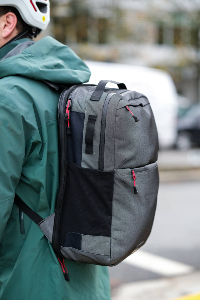 Two Wheel Gear Grey Inverter Pannier Backpack being being carried as backpack by man